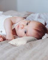 Duftkissen "dream sweet little one" in Anwendung. Baby liegt mit dem Kopf neben dem beruhigenden Kräuterkissen.