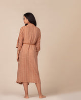 Rückansicht einer Frau, die den Morgenmantel in terrakotta trägt.