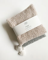 Zwei Kirschkernkissen aus Teddystoff: cozy creme und grau mit Banderole: cozy cushion