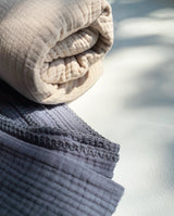 Kollektion aus zwei Musselindecken für Babys in sand und grau.