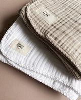 Kollektion aus zwei Farbvariationen Musselindecken für Babys: sand und weiß