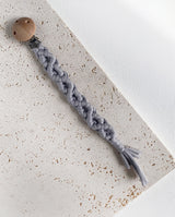 Schnullerband aus Stoff im Makramee Design mit Holzclip in der Farbe hellgrau.