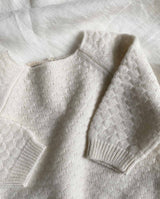 Nahaufnahme des Baby Cashmere Sweater in creme mit Bündchen an den Ärmeln.