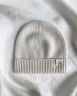 Baby Mütze aus Cashmere mit Logo am Bündchen in creme.
