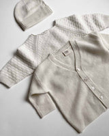 Kollektion aus Cashmere Produkten in creme: Baby Cashmere Cardigan, Sweater und Mütze.
