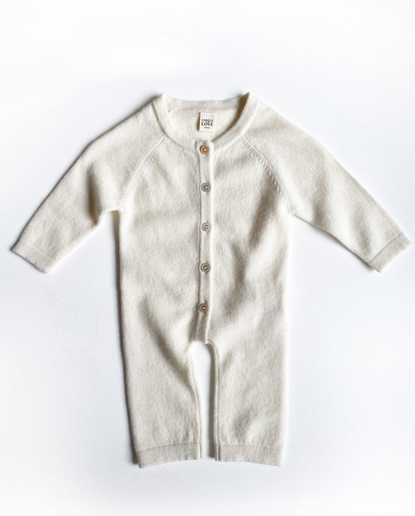 Baby Cashmere Overall in creme mit langen Armen und Beinen, einer Knopfleiste und einem Rundhalsausschnitt.