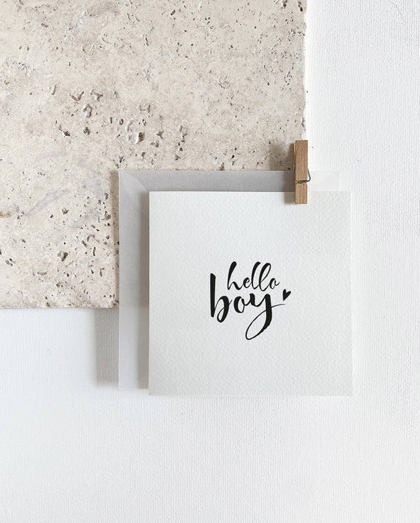 Quadratische Grußkarte zum Klappen mit milchigem Briefumschlag und Holzklemme. Spruch: "hello boy"