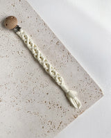Schnullerband aus Stoff im Makramee Design mit Holzclip in der Farbe creme.